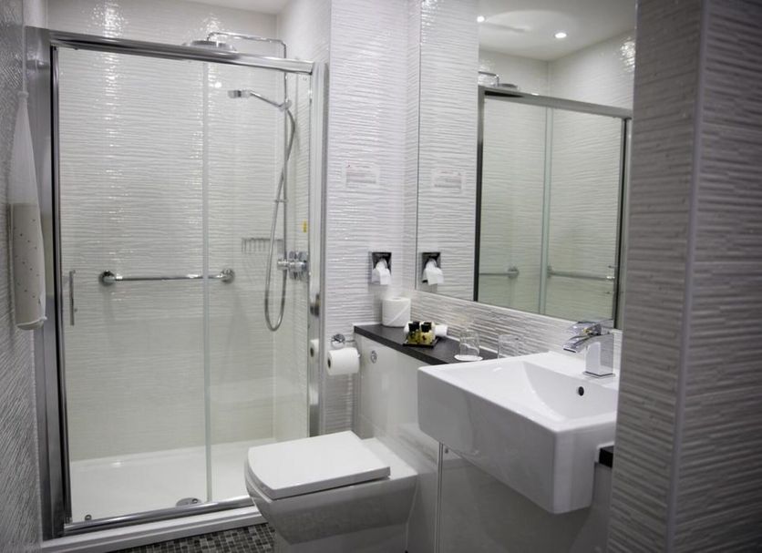Keswick Country House Hotel bathroom with glass shower, wall mirror, and wall-mounted sink in Keswick