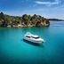 The Danai, Nikiti: luxury yacht on turquoise sea beside a tree-lined coastline