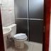 Pousada Ilha Morena bathroom in Florianopolis with toilet, sink and frosted glass shower enclosure