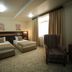 Onyx Hotel Bishkek guest room with two twin beds, window curtains, and patterned armchair