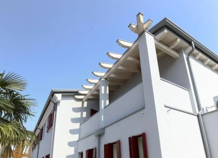 Venice Airport Villa Erica 1 in Venice, white villa exterior with red-shuttered windows and pergola roof