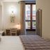 Hotel Il Tiglio in Castel di Sangro guest room with bed, desk, wall lamp and balcony door