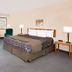 Days Inn by Wyndham Boonville guest room with king bed, sofa, coffee table and two lamps