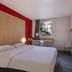 B&B HOTEL La Rochelle Centre guest room with double bed, desk by window, and wall-mounted TV
