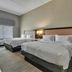 Hampton Inn Buffalo - Amherst guest room with two beds, window, TV, and dresser in Amherst