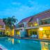 Belle Villa Resort, Pai courtyard pool between two villas with lit balconies and palm trees