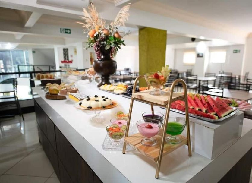 Havana Palace Hotel I in Uberaba breakfast buffet with pastries, fruit, and indoor dining area