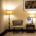 Rodeway Inn & Suites Corpus Christi Northwest lobby seating area with two chairs, lamps, and side table