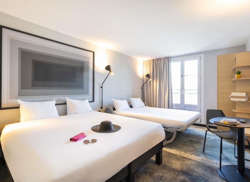 ibis Strasbourg Centre Gare room with two beds, desk, and floor-to-ceiling window in Strasbourg