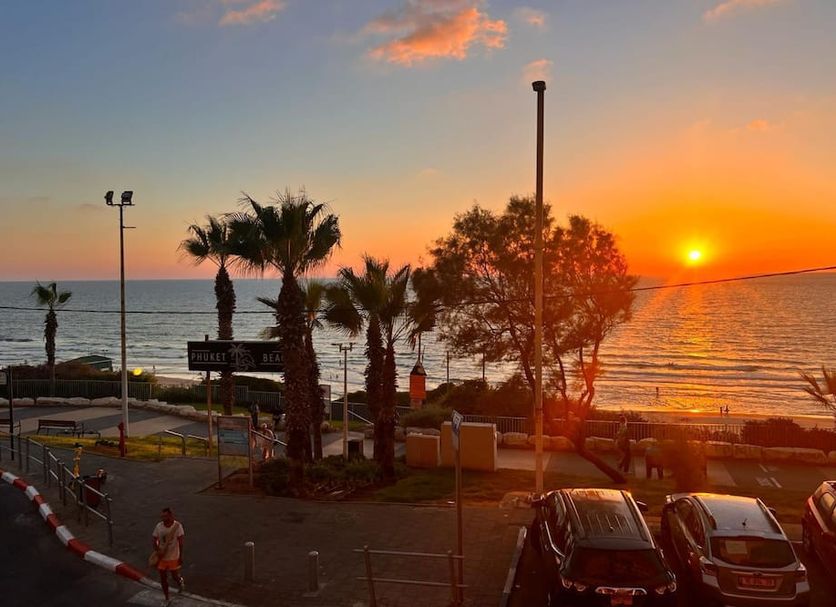 Elis Boutique Hotel, Bat Yam, with sunset sea view and palm trees along the waterfront