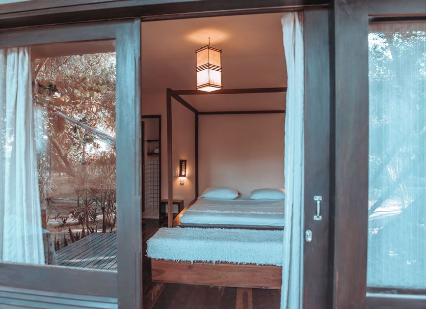 Pousada Fortal Jeri bedroom with canopy bed and glass doors in Jijoca de Jericoacoara