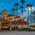 La Quinta Inn and Suites by Wyndham Orlando Airport in Orlando exterior with palm trees at dusk
