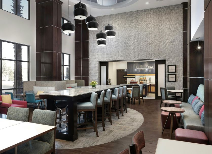 Hampton Inn & Suites El Paso-East lobby with bar seating, lounge chairs, and tall windows