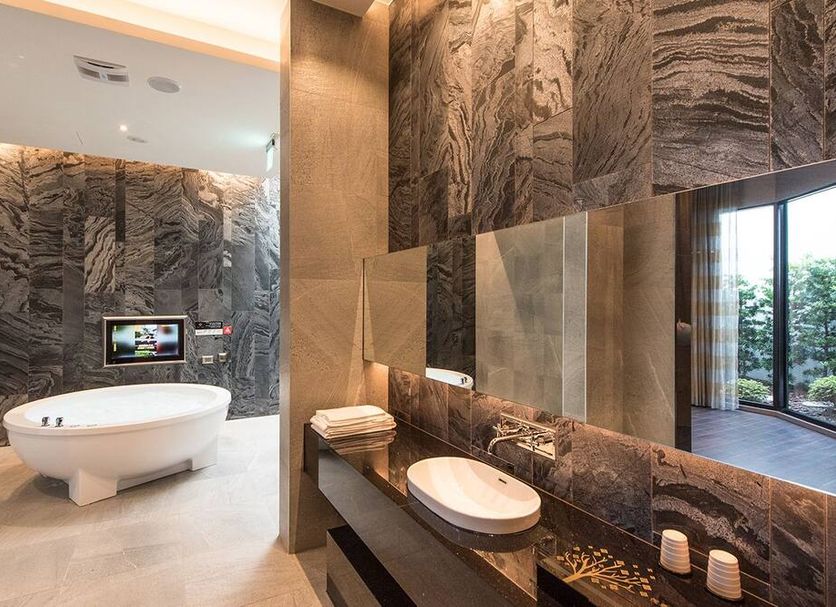 Voga Motel Taichung City bathroom with freestanding tub, stone walls, double vanity and floor-to-ceiling window