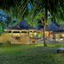 Constance Lemuria in Grand'Anse Praslin: palm-framed resort lawn with loungers and thatched villas