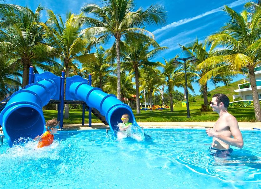 Sea Links Beach Hotel in Mũi Né with a blue waterslide into a palm-lined pool