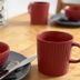 Haus Hohensee in Clausthal-Zellerfeld: red breakfast bowl, mug and cutlery on a table