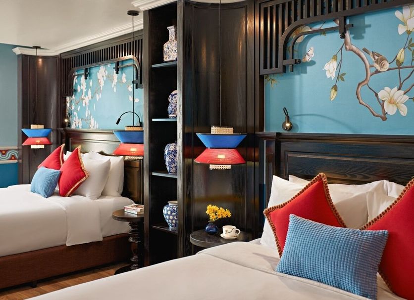 Eliana Signature Hanoi Hotel room with two beds, floral wall art, and colorful pillows in Hanoi