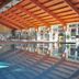 Indoor pool at Hotel Hajnal in Mezőkövesd with wood-beamed ceiling and large windows
