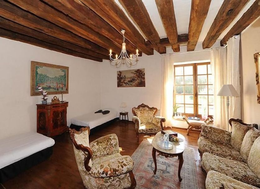 Chateau De Jallanges in Vouvray, elegant lounge with exposed wood beams, fireplace and floral seating