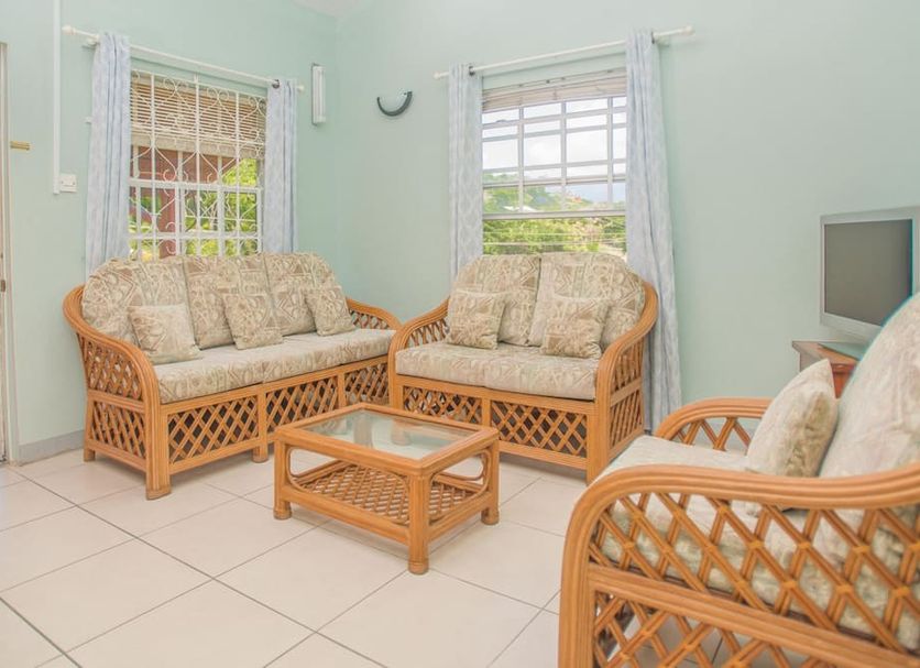 Bougainvillea Apartments, St. George's: airy sitting area with wicker sofas, coffee table and tiled floor