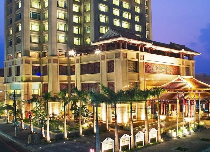 Ttc Imperial Hotel in Hue at dusk, with illuminated tower, palm trees, and grand entrance