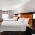 Home2 Suites by Hilton Alexandria guest room with two queen beds, desk, and cabinet storage