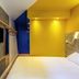 Hôtel ibis budget Fontainebleau Avon guest room with bed, wall TV, and blue door in Avon