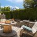 Hotel La Fontaine in Les Houches: mountain-view terrace with stone seating and a round table set for drinks and food