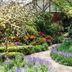 Elizabethan Lodge in Blackburn garden with winding path, colorful flowers, and lush greenery