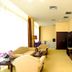 Binhai Jianguo Hotel in Tianjin lounge with beige sofas, TV stand, and floor lamp