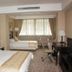 Xiang Ming Holiday Hotel in Huangshan guest room with two beds, desk, TV, and large window