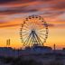 La Villa Andry in Ouistreham with a Ferris wheel silhouetted at sunset