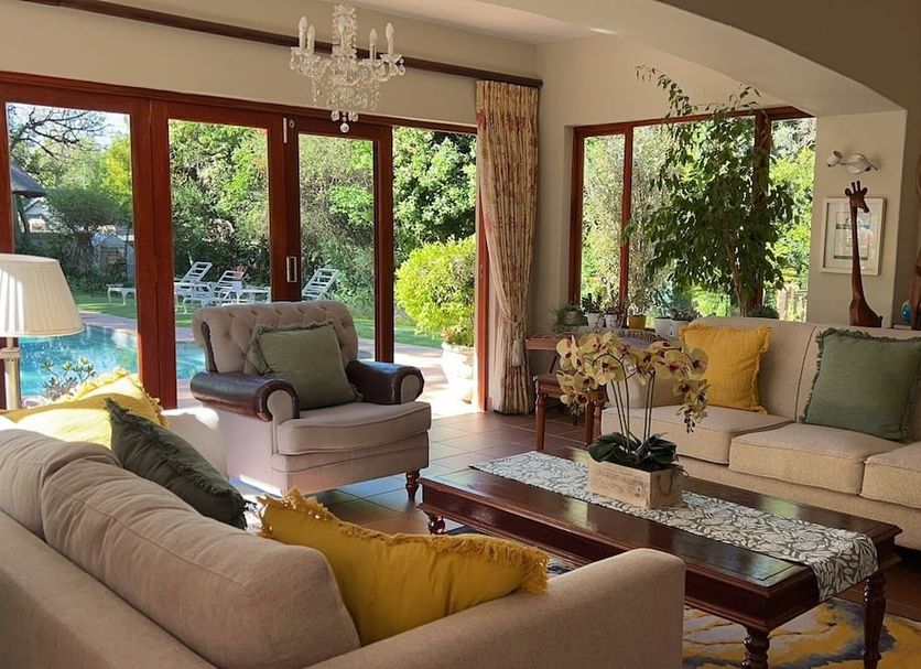 Bellgrove Guest House Sandton living room with pool view and large garden-facing glass doors in Johannesburg