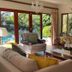 Bellgrove Guest House Sandton living room with pool view and large garden-facing glass doors in Johannesburg