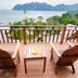 Phi Phi The Beach Resort in Ko Phi Phi with wooden deck chairs overlooking a tropical bay and limestone islands
