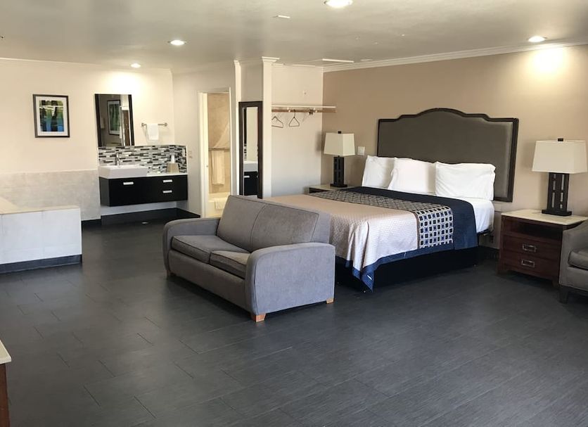 Economy Inn LAX Inglewood room with king bed, sofa, and vanity area in Inglewood