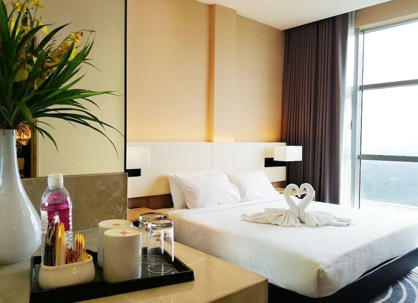 Regalia Upper View Hotel Kuala Lumpur room with bed, bedside lamps, and city view through window