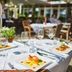 Outdoor dining table at Living Hotel am Olympiapark in Munich with plated dishes and wine glasses