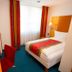 Zollamt Design Hotel Kaiserslautern guest room with single bed, desk, lamp and colorful curtains