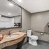 Quality Inn & Suites Biloxi - Ocean Springs bathroom with vanity, toilet, mirror, and towel rack