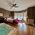 The Ludington House, Ludington: room with whirlpool tub, four-poster bed, bay windows and red loveseat