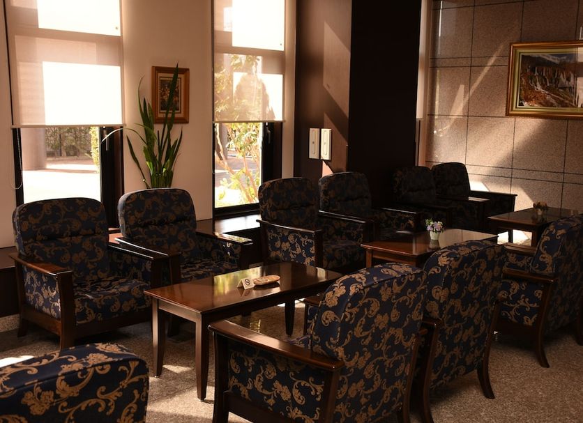 Hotel Route-Inn Koriyama Minami lounge with patterned armchairs, sofas, and large windows in Kōriyama