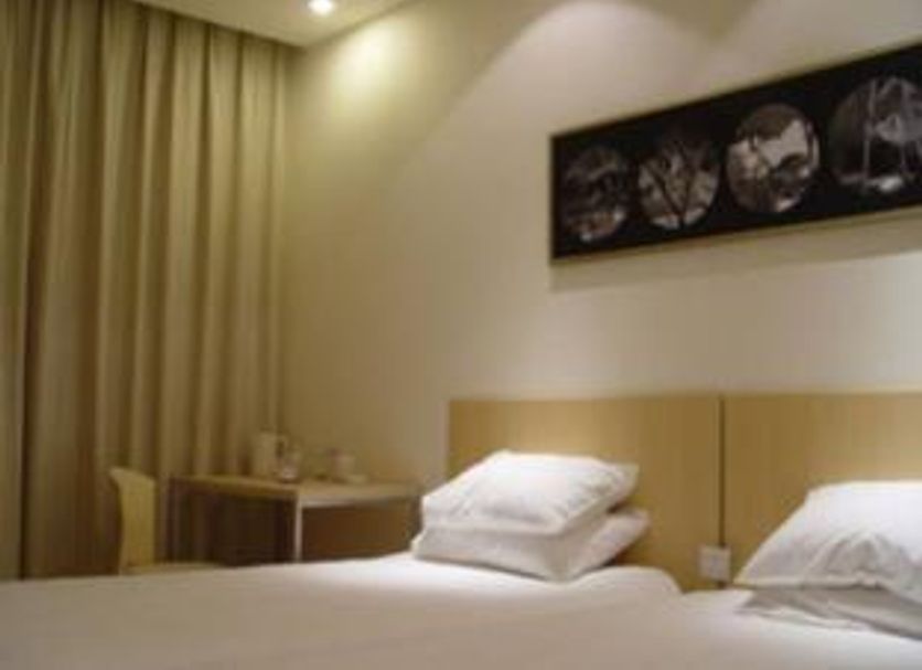 Pod Inn Nanjing Xuanwu Lake Xuanwumen Station room with twin beds, curtains, and wall art in Nanjing