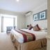 Twin Towers Inn in Artarmon guest room with king bed, seating area and balcony doors
