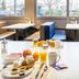 B&B Hotel Düsseldorf-Hilden breakfast table with coffee, orange juice, bread, eggs and seating in Hilden