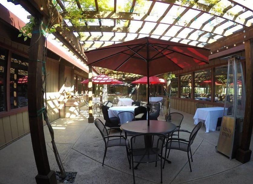 Ridgemark Golf Club And Resort in Hollister patio dining area with tables, chairs, and red umbrellas