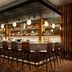 Moxy Asheville Downtown bar interior in Asheville with long wooden counter and hanging pendant lights