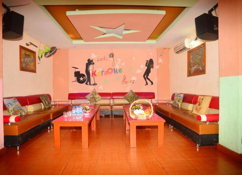 Karaoke lounge at Central Hotel in Quang Ngai with red sofas, tables, and wall art