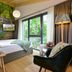 Hotel Fire & Ice Düsseldorf/Neuss room with bed, forest mural, floor lamp and green balcony view in Neuss